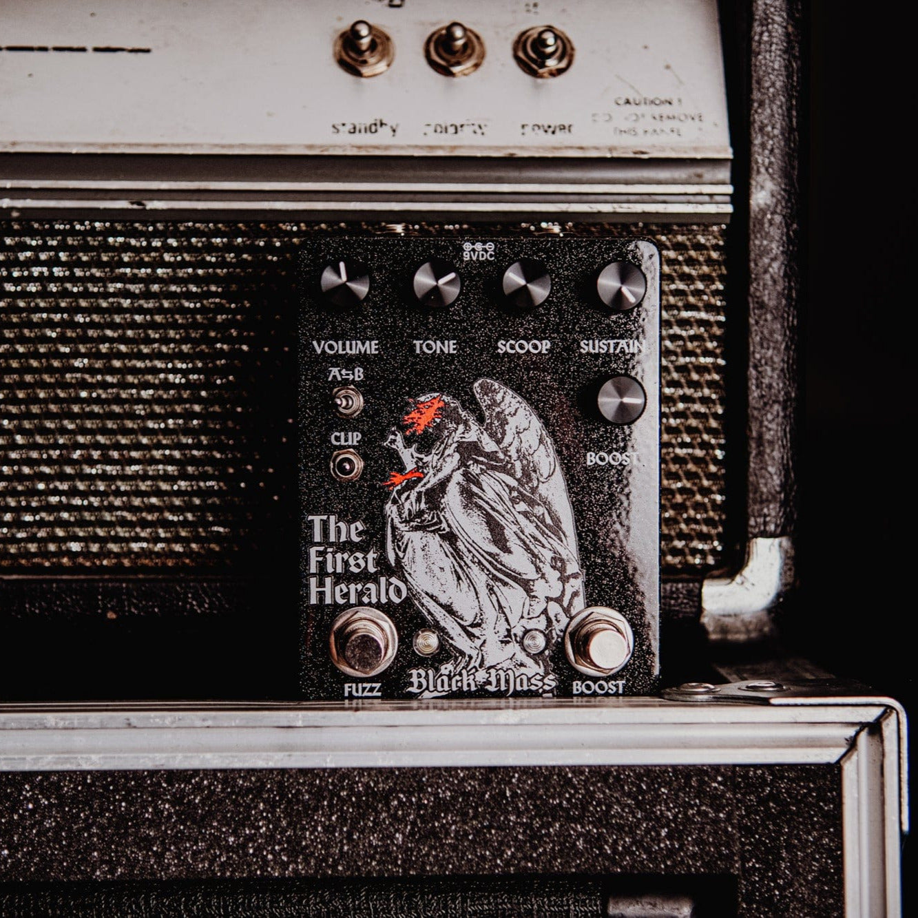 Vintage-style amplifier with 'The First Herald' branding on a black background